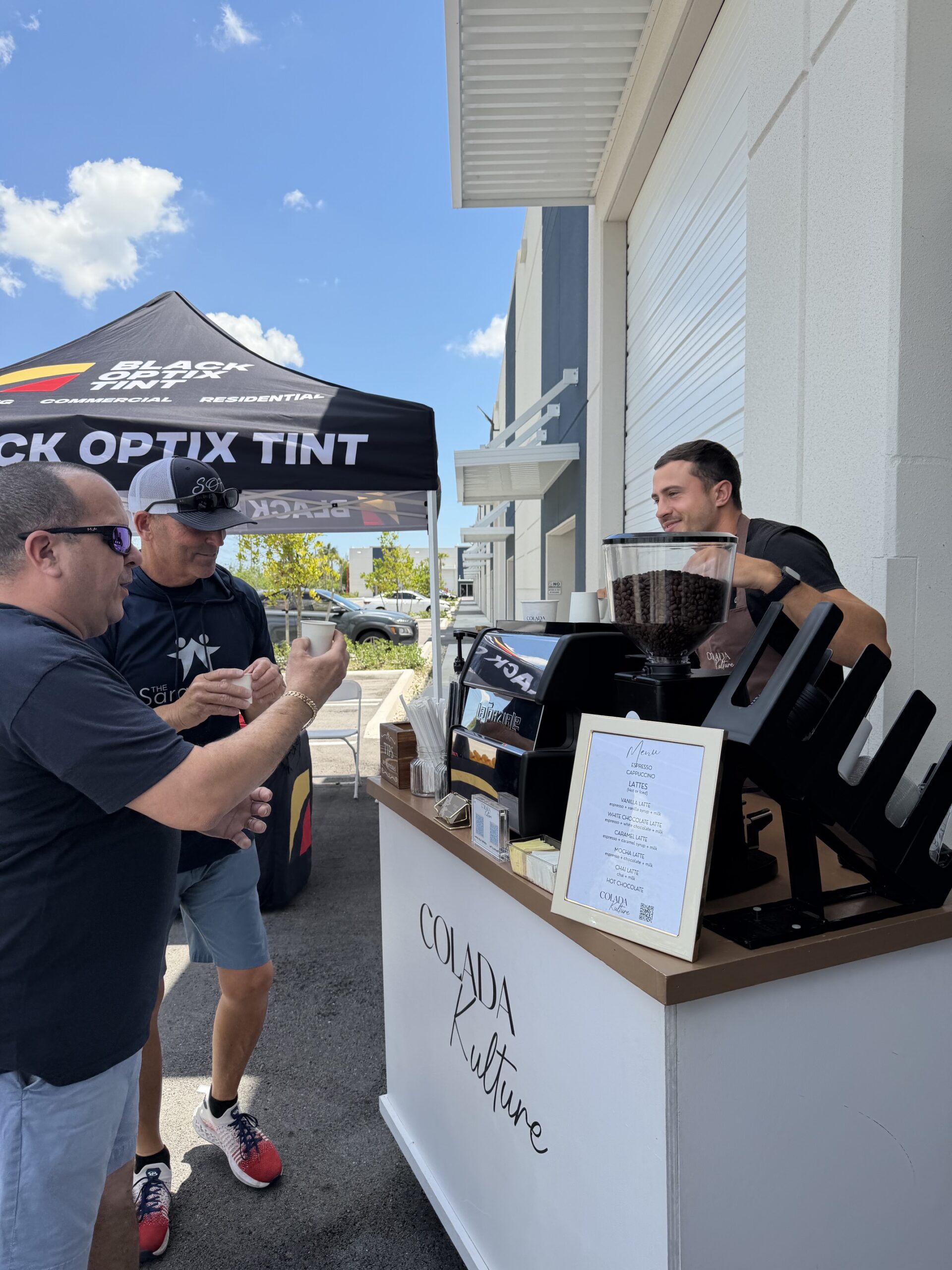 Colada Kulture coffee cart serving guests at a Black Optix Tint grand opening event in Doral, Florida