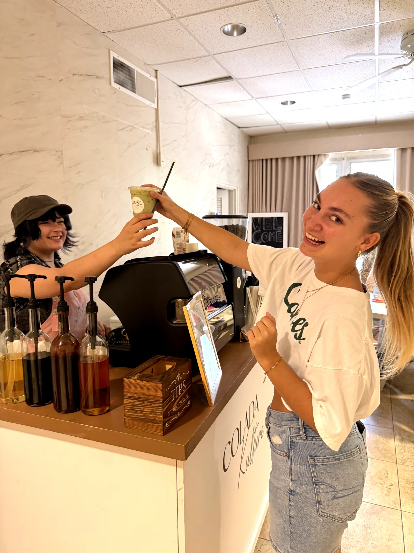 Barista handing off a matcha latte at the Colada Kulture coffee cart at UM sorority
